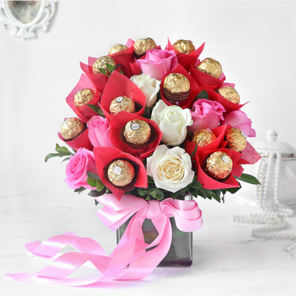 pink and white roses arrangement with chocolates