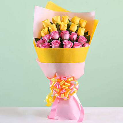 pink and yellow roses bunch in paper packing